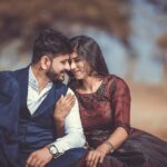 A loving couple sharing a tender moment outdoors, highlighting their romantic connection and stylish attire.